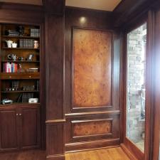 Faux burl and wood grained panels and mahogany wood grained walls filled shelves